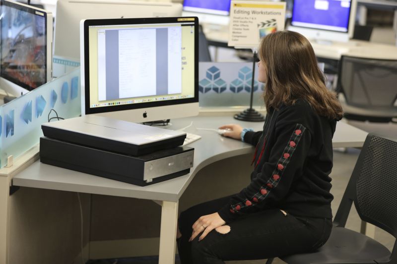 Scanner next to student using computer