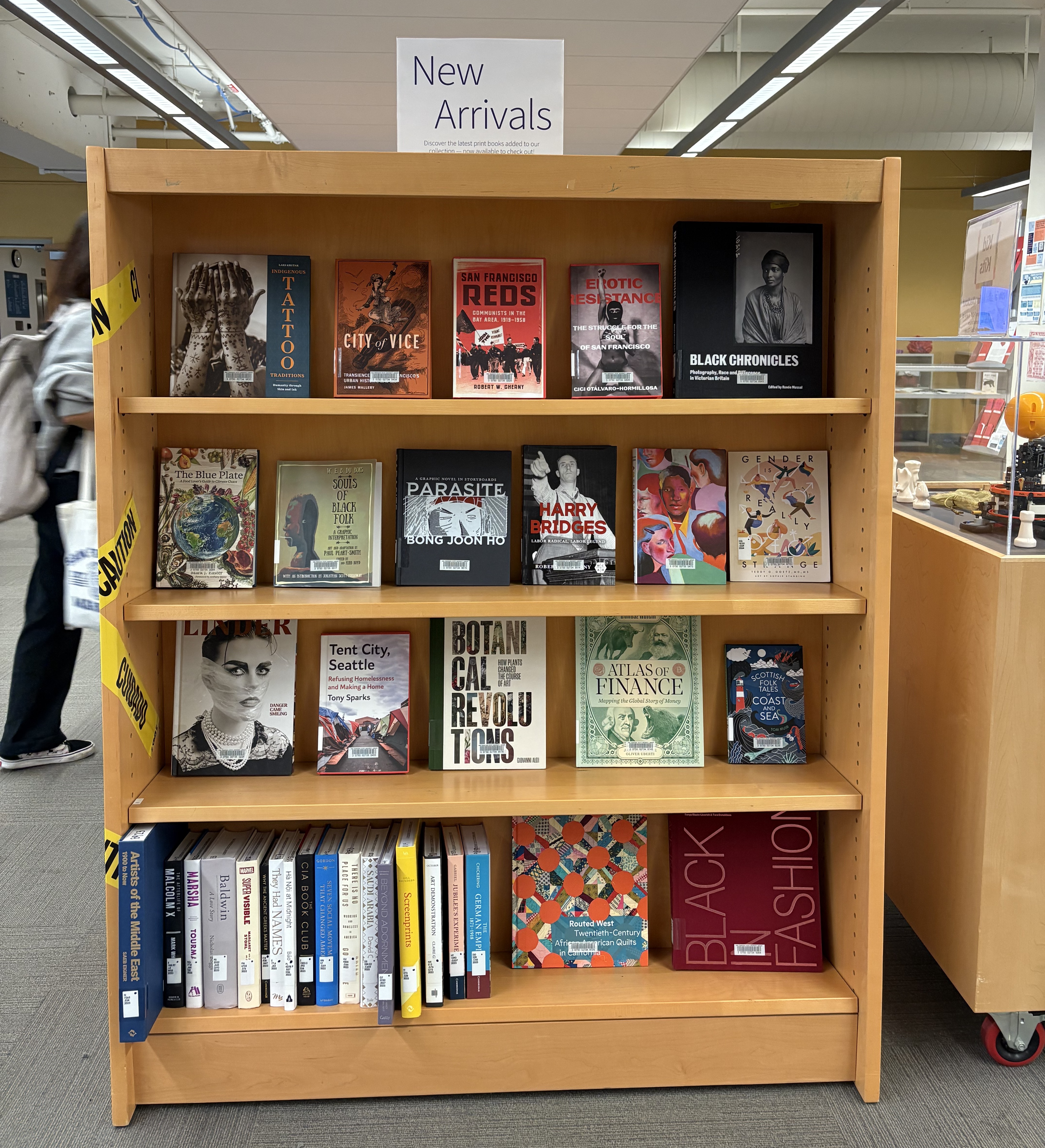 Wooden shelf with books on various topics displayed face out