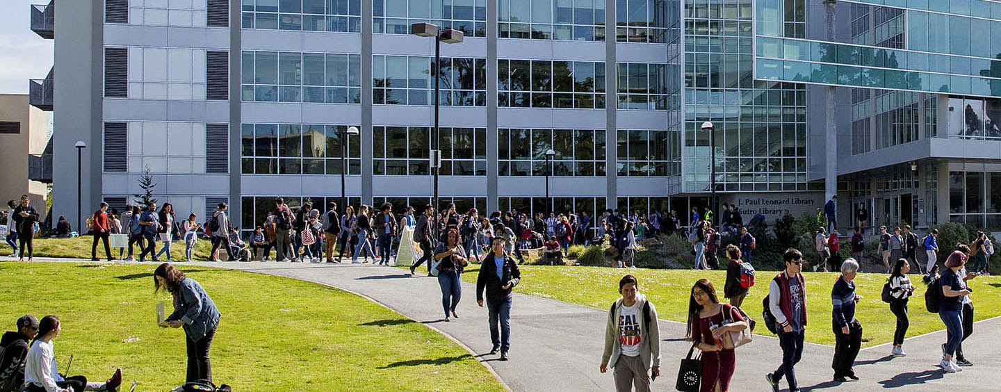 People walk across the quad in front of the J. Paul Leonard Library