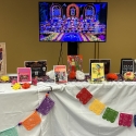 Books and materials on a table decorated with flowers and papel picado