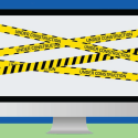 Computer wrapped in yellow-and-black "Under Construction" tape