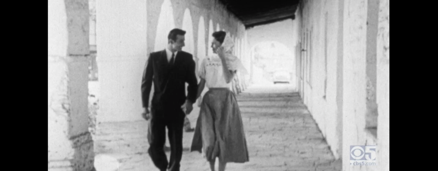 A young couple holding hands in a black-and-white film still