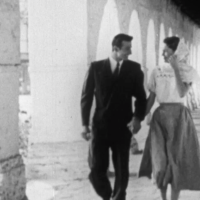 A young couple holding hands in a black-and-white film still