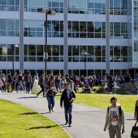 People walk across the quad in front of the J. Paul Leonard Library